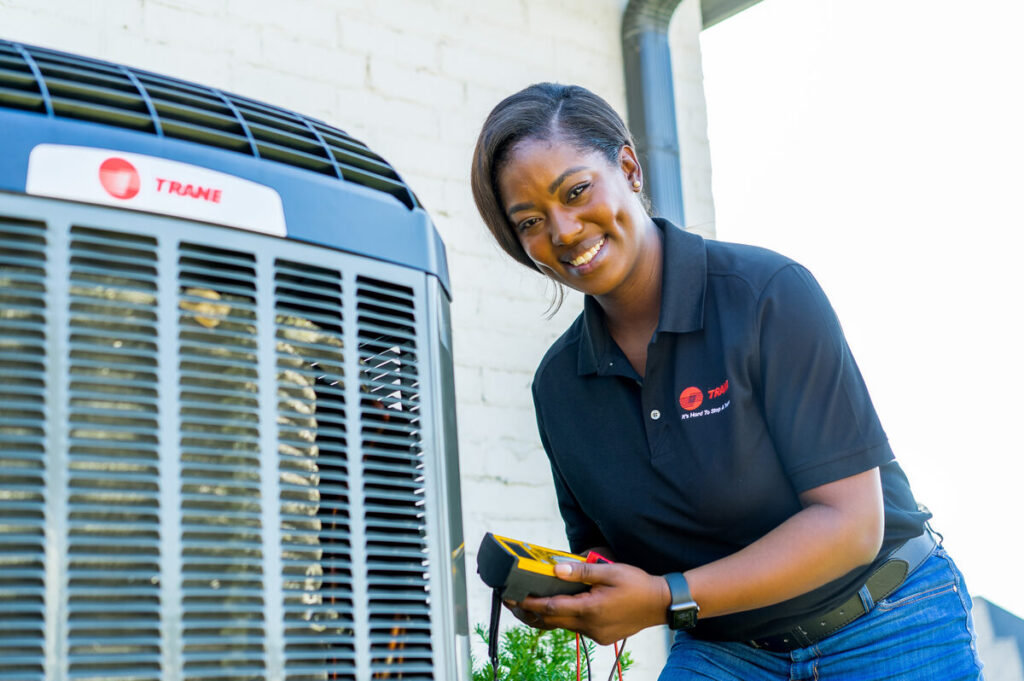 HVAC technician servicing a residential outdoor air conditioner