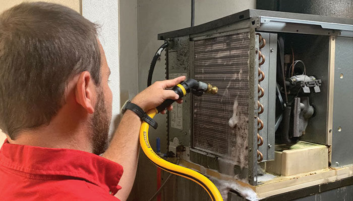 Technician inspecting commercial kitchen HVAC or restaurant equipment